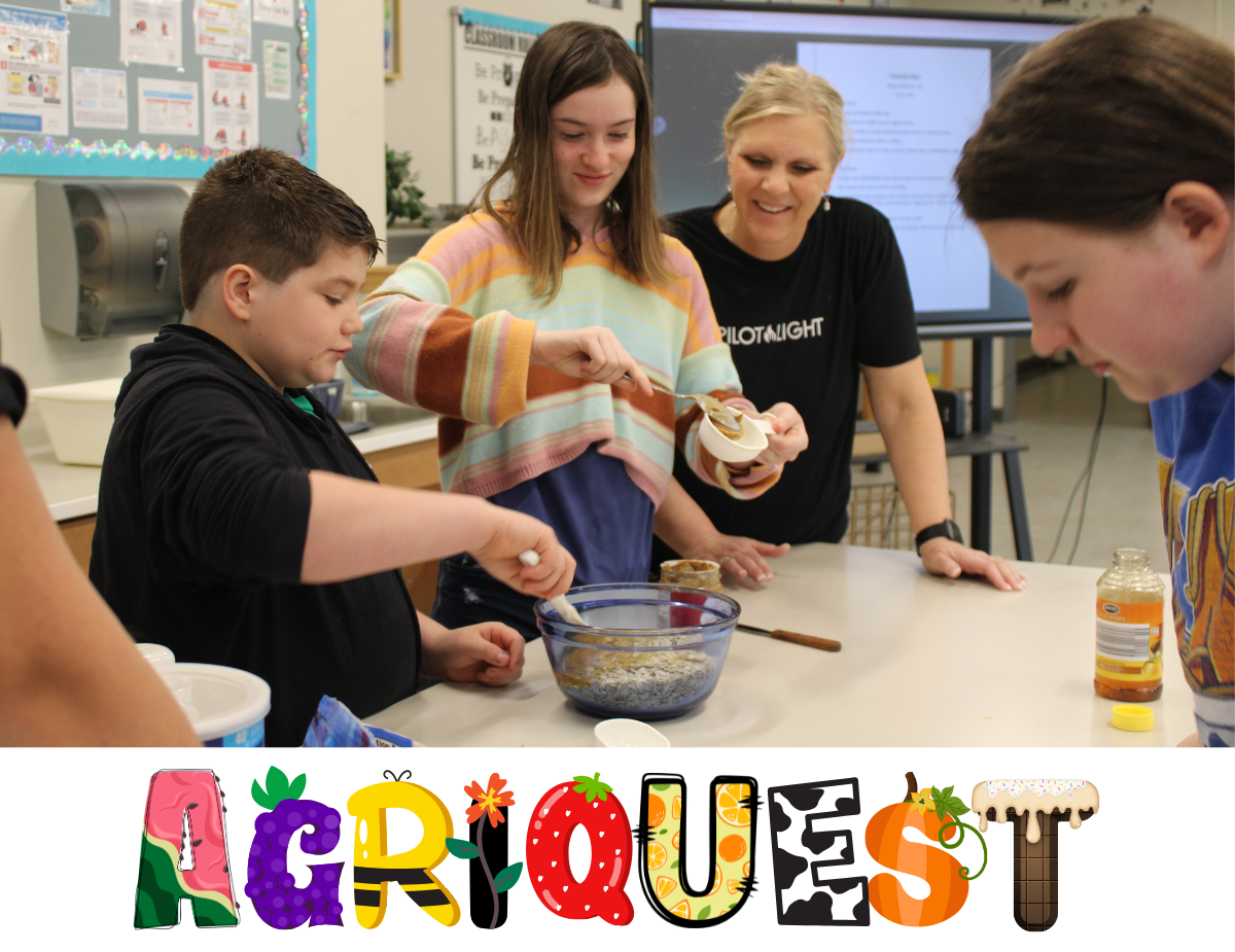 Young students cook in a kitchen with their teacher, pictured with a graphic that reads "Agriquest" using letters that look like food.
