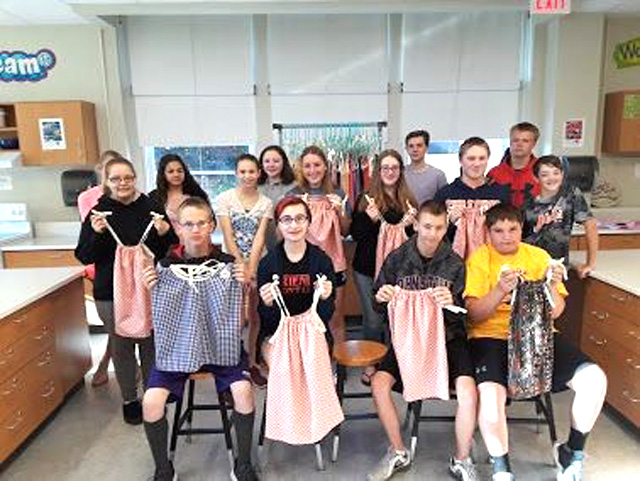 group photo of students holding up dresses