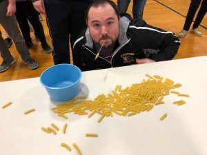 man sitting in front of pile of pasta