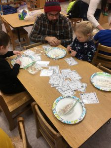 adult and children creating something with paper plates