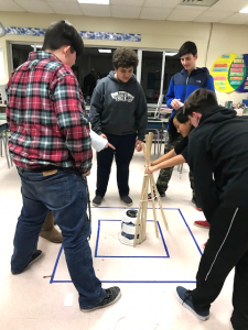 four students working to assemble a project