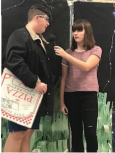 two students, one holding a pizza box