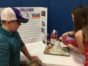 two students demonstrating their volcano project