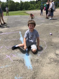 boy drawing with chalk on playground