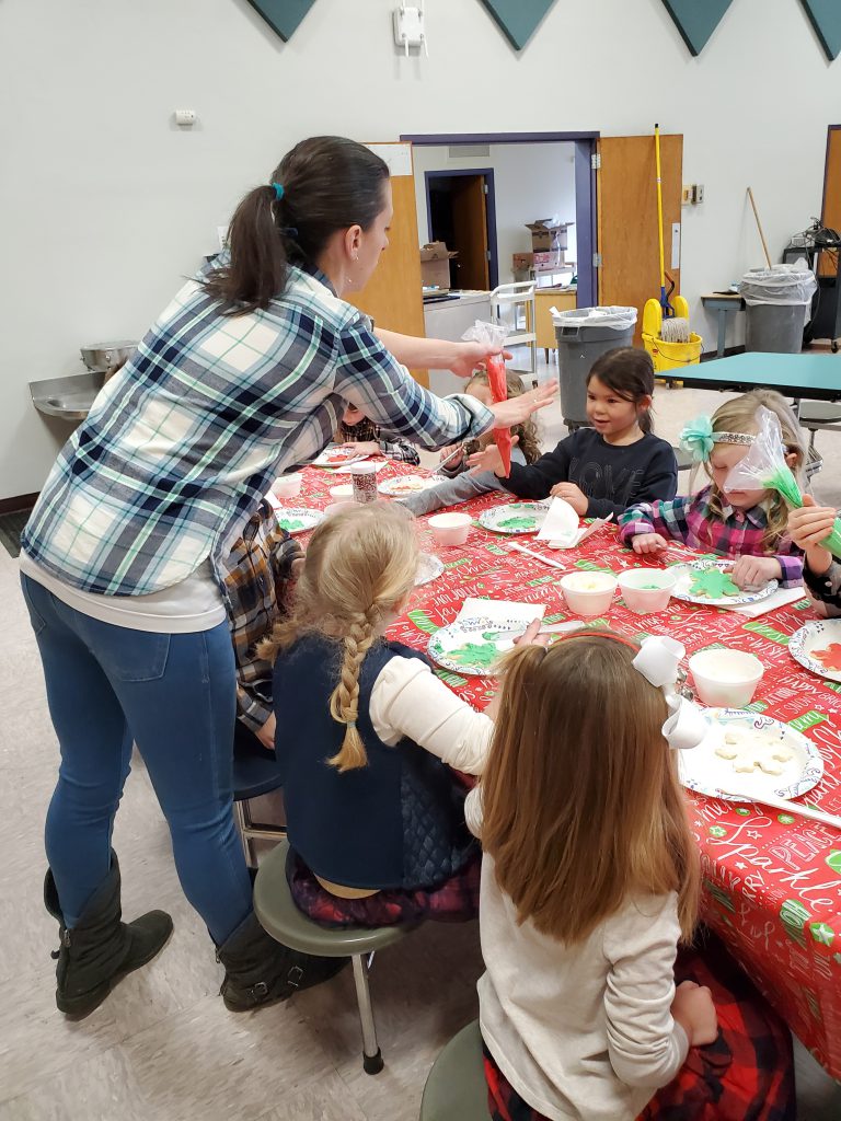 Chef helping students decorate