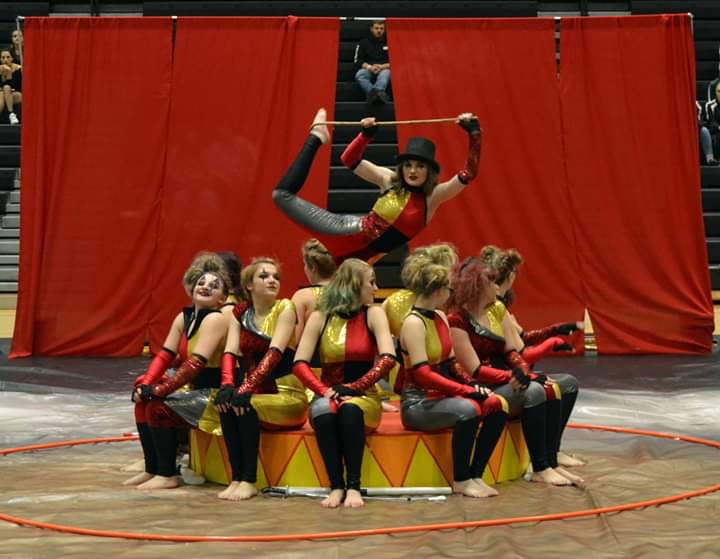 winter guard troupe posing for a seated group photo