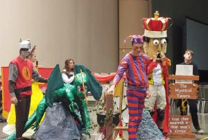 students dressed up in costumes perform a skit on a stage