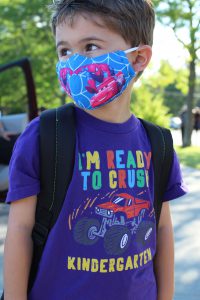 a boy wearing a purple tshirt that reads "I'm ready to crush kindergarten" and wearing a Spider Man facemask
