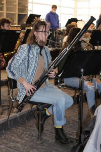 a young woman plays a bassoon