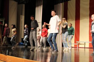 students practice a dance number on a theatrical stage
