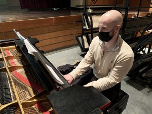 a bald man plays the piano