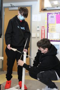 two male students work on a wind turbine project together