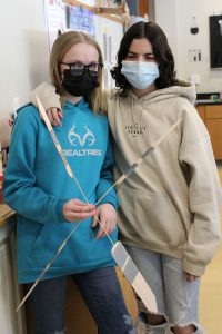two female students work together as partners to build a wind turbine