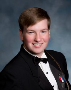 a boy wearing a bowtie and black jacket smiles at the camera