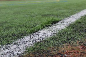 a close up shot of football turf showing a spot where turf is pulled up and damaged