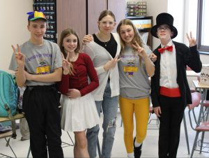 five students pose inside a classroom, while in costume