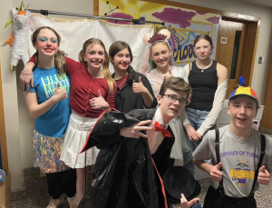 students in costume pose together in a classroom