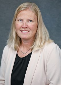 a blonde woman with an off-white blazer and black shirt