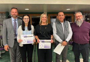 Three men and two women pose holding certificates