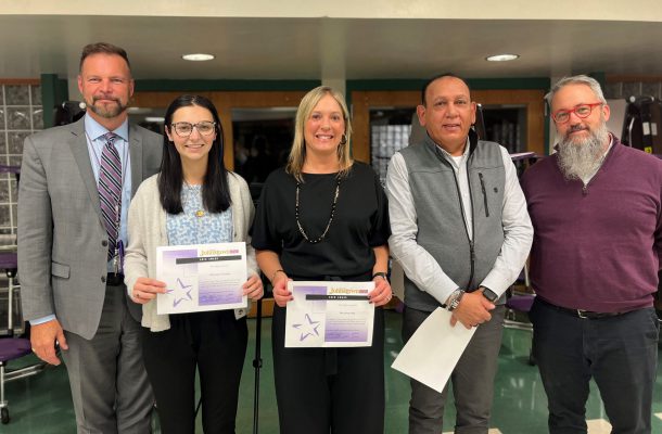 Three men and two women pose holding certificates