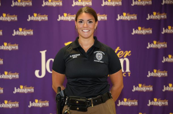 a police officer stands in front of a purple curtain