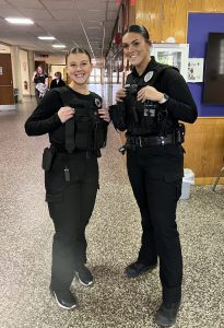 a police officer poses next to a student who is dressed up like her