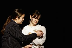 two young female actors hold a prop baby