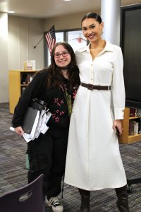 a woman wearing a white dress poses with a high school aged female student