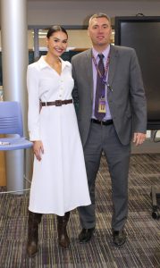 a woman in a white dress poses next to a man wearing a suit