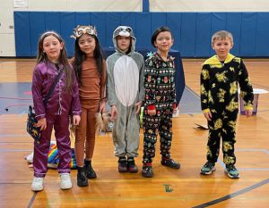 students in costume pose in a gymnasium