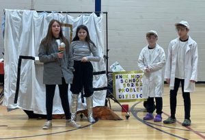 four students perform a skit in a gymnasium