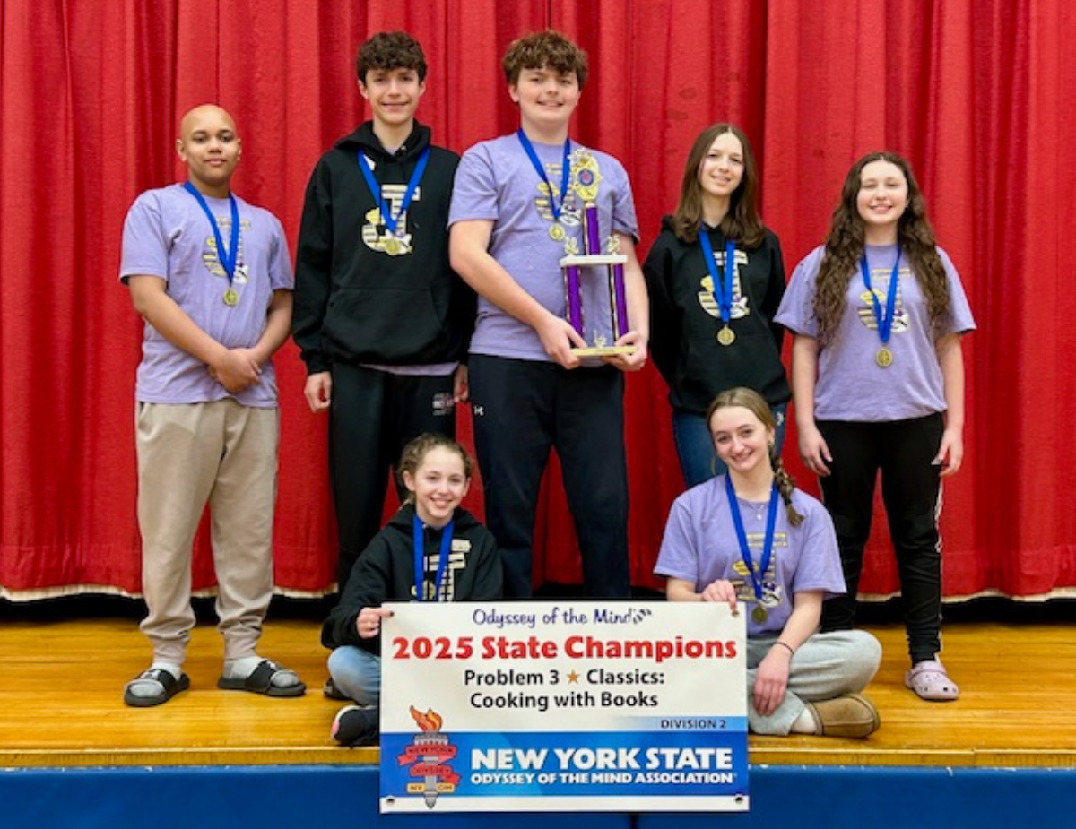 seven middle school students pose on a stage in front of a red curtain
