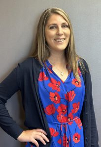 Nicole Panton wearing a blue and red dress with a navy cardigan