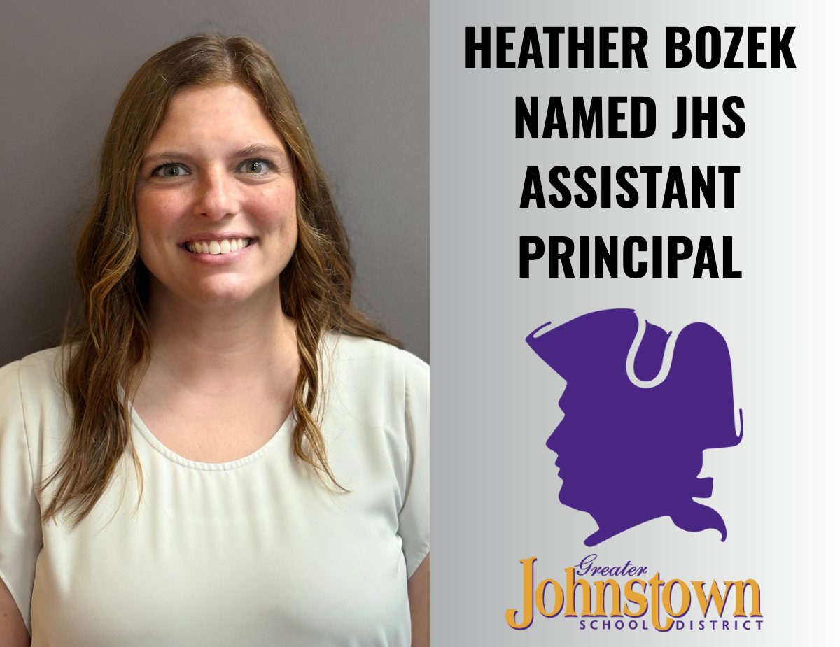 a woman with red hair wears a white shirt and smiles into the camera; text reads "Heather Bozek Named JHS Assistant Principal"