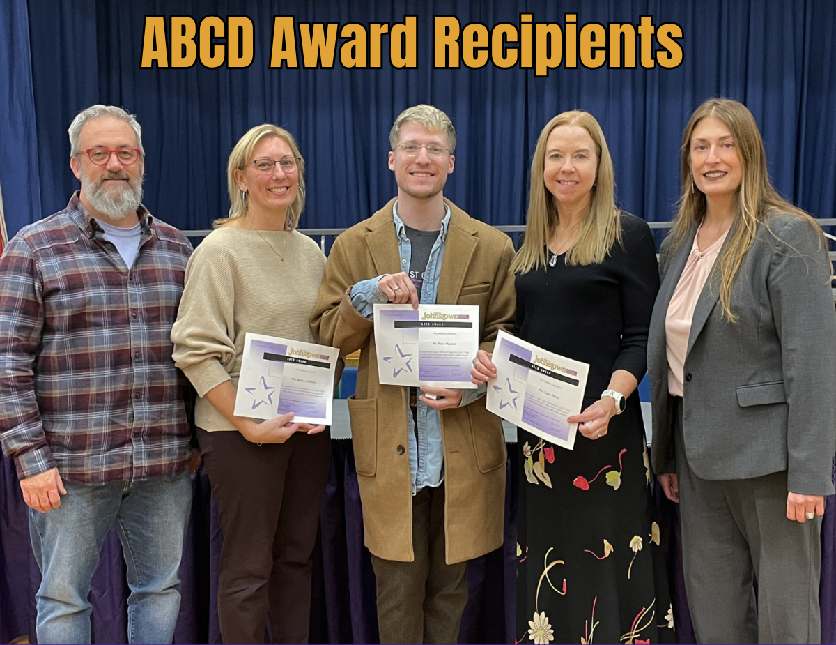 five adults pose, with three of them holding certificates with the text "ABCD Award Recipients."