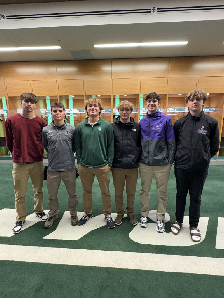 male teen students stand inside of the locker room for a professional football team 
