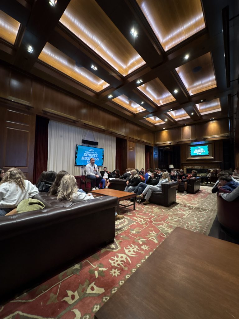 an adult male addresses a group of students