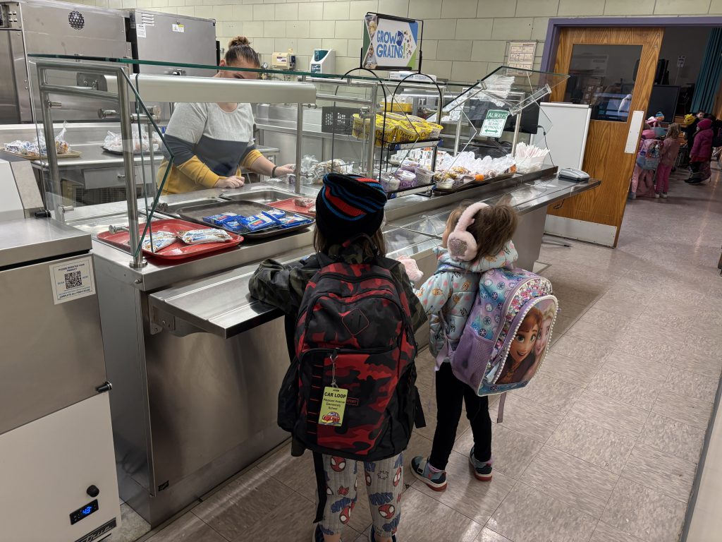 two students go through the cafeteria serving line
