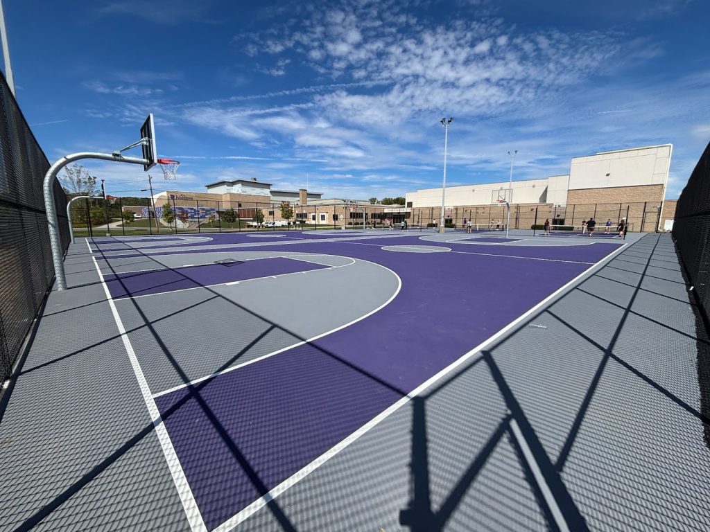 an outdoor basketball court with purple and grey colors