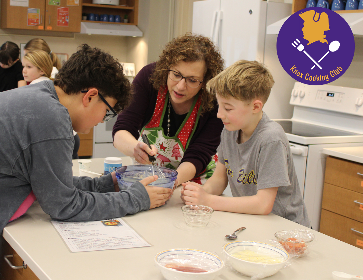 a woman helps two young boys with a cooking recipe