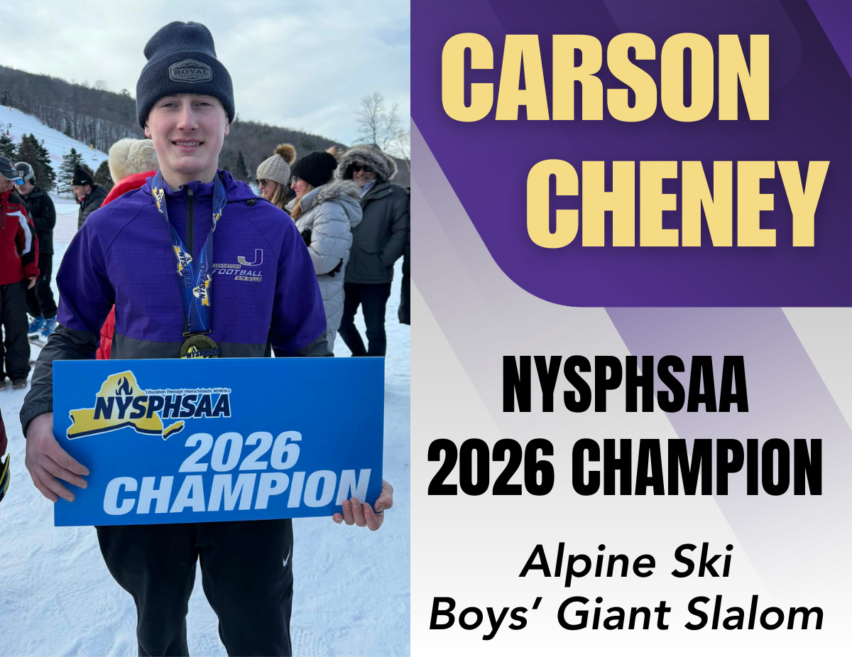 a young man holds a blue sign that reads "NYSPHSAA 2026 Champion" wile standing outside in the snow