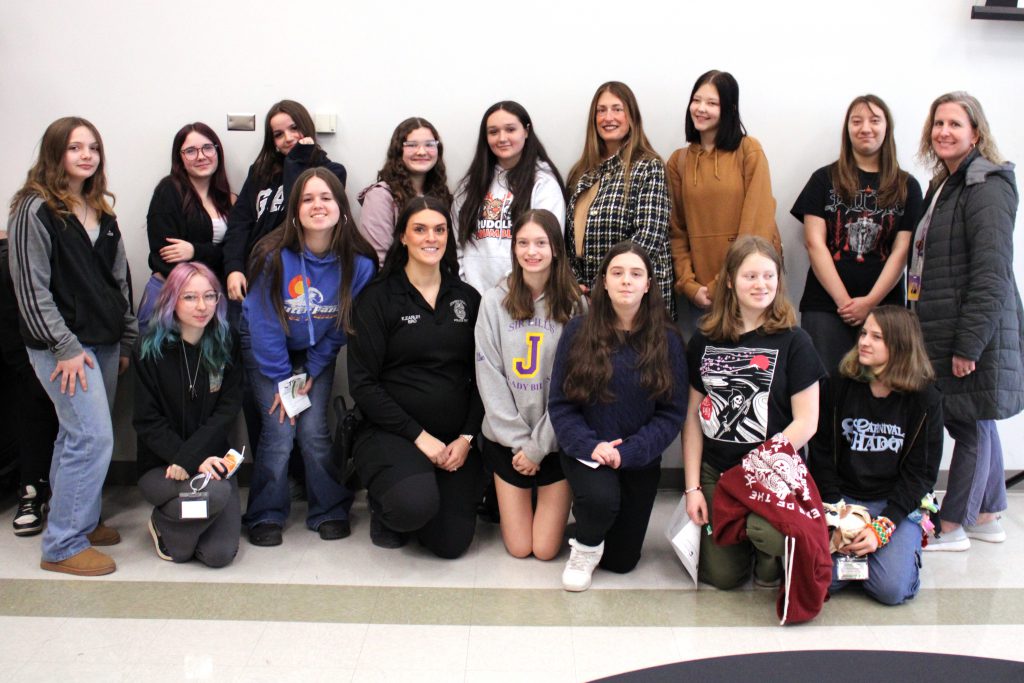 a group of female students poses with three adult women