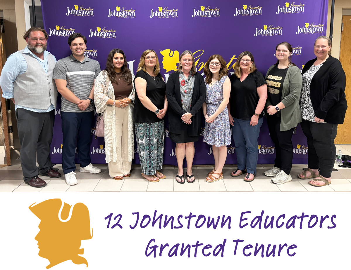 a group of nine teachers poses in front of a purple and gold banner with text that reads "12 Johnstown Educators Granted Tenure"